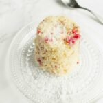 Mug cake with raspberries and coconut on a plate
