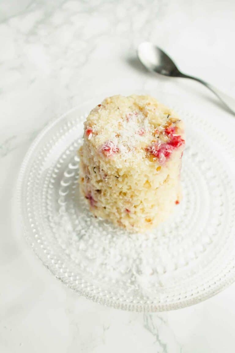 Easy vegan raspberry & coconut mug cake in 5 minutes Mug cake with raspberries and coconut on a plate